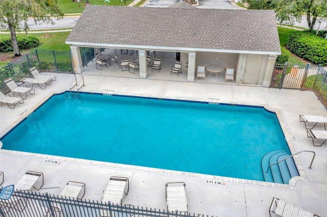 view of swimming pool featuring a patio area and a bar