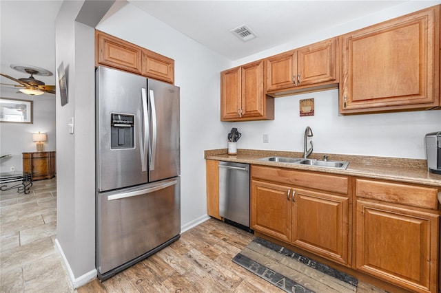 kitchen with light hardwood / wood-style flooring, stainless steel appliances, ceiling fan, and sink