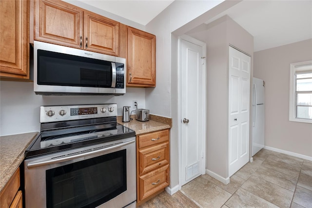 kitchen featuring stainless steel appliances and light tile patterned floors