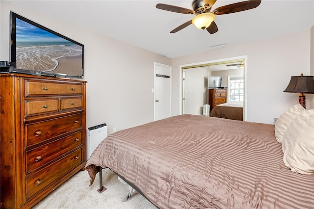 bedroom featuring light carpet, radiator, a closet, and ceiling fan