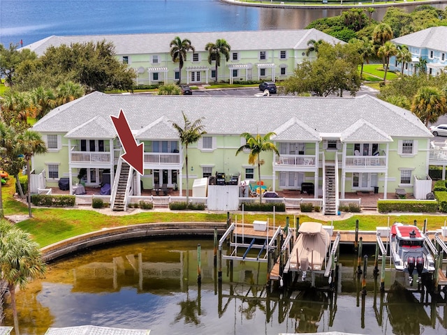 rear view of property featuring a balcony and a water view