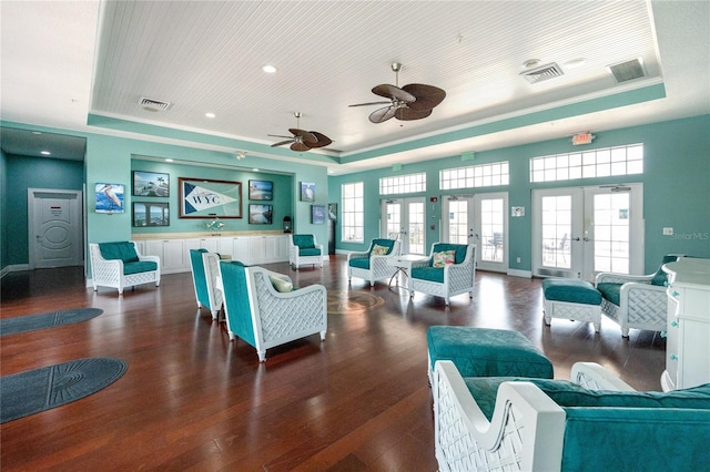 dining space featuring french doors, a raised ceiling, dark wood-type flooring, and ceiling fan