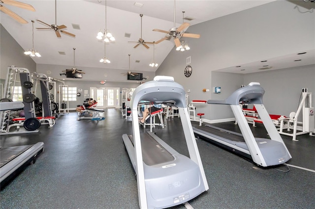 exercise room featuring ceiling fan with notable chandelier and high vaulted ceiling