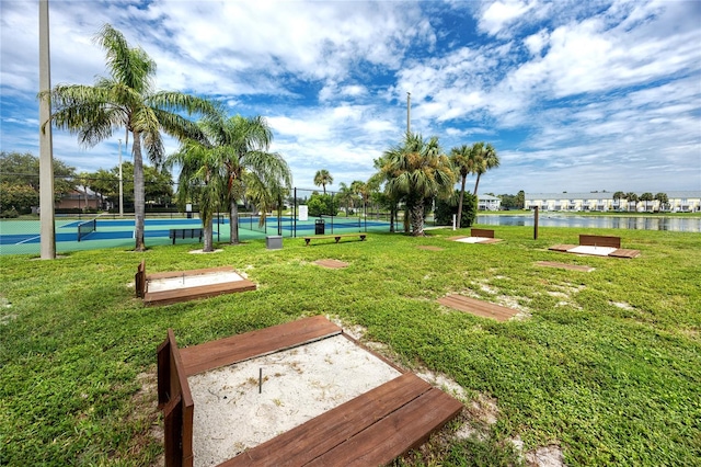 view of home's community featuring a water view, tennis court, and a yard