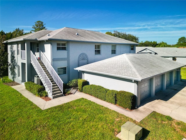 view of front of house with central air condition unit, a garage, and a front yard