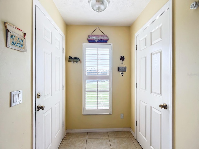 entryway with a textured ceiling and light tile patterned flooring