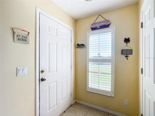 doorway to outside with light tile patterned floors