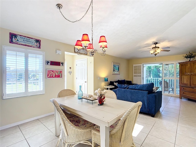 tiled dining room with ceiling fan with notable chandelier