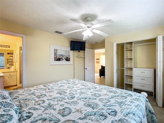 bedroom featuring a closet, ceiling fan, connected bathroom, and a textured ceiling