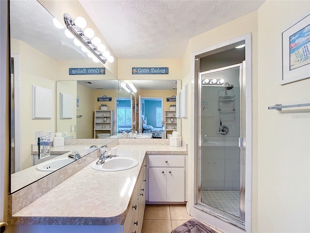 bathroom with vanity, a textured ceiling, walk in shower, and tile patterned floors