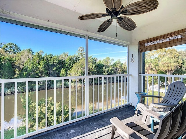 unfurnished sunroom featuring a water view and ceiling fan