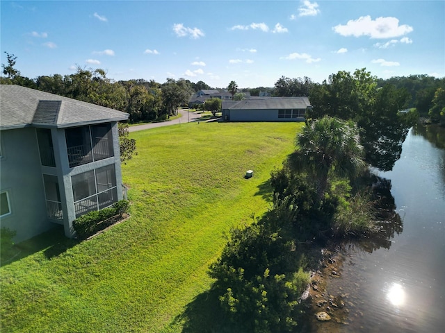 view of yard featuring a water view and a sunroom