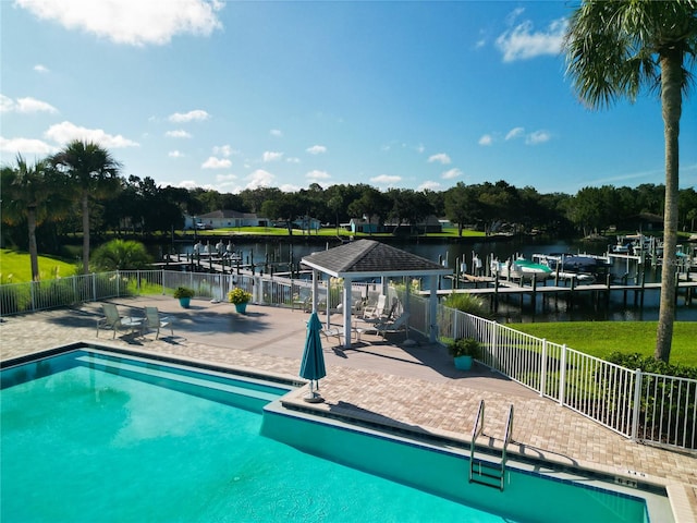 view of swimming pool featuring a patio and a water view