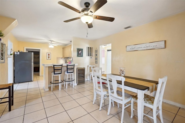 tiled dining area with wine cooler and ceiling fan