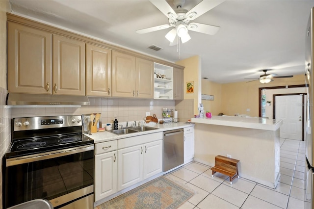 kitchen featuring sink, stainless steel appliances, backsplash, kitchen peninsula, and light tile patterned floors