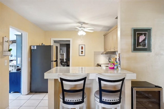 kitchen featuring kitchen peninsula, a breakfast bar, wine cooler, and appliances with stainless steel finishes