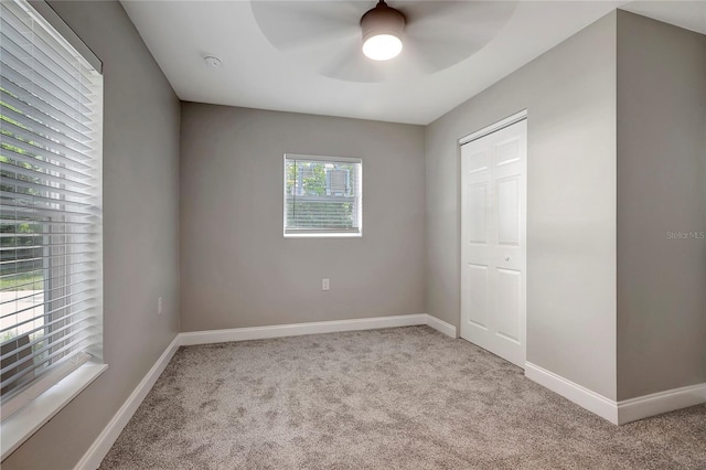 unfurnished bedroom with a closet, ceiling fan, and light colored carpet