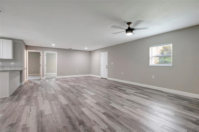 unfurnished living room with light wood-type flooring and ceiling fan