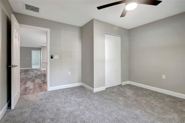 unfurnished bedroom featuring carpet floors, ceiling fan, and a closet