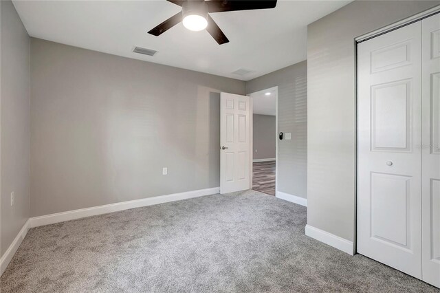 unfurnished bedroom with a closet, ceiling fan, and carpet floors