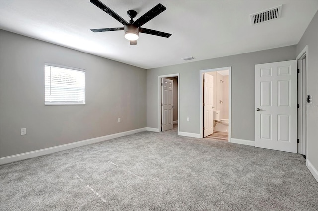 unfurnished bedroom featuring light colored carpet, ceiling fan, and ensuite bathroom