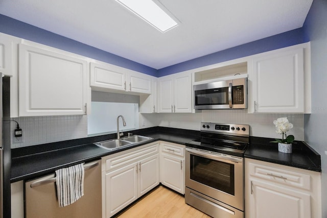 kitchen featuring light hardwood / wood-style flooring, sink, appliances with stainless steel finishes, and white cabinets