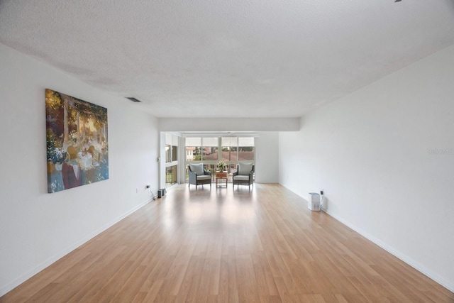 empty room featuring light wood-type flooring and a textured ceiling