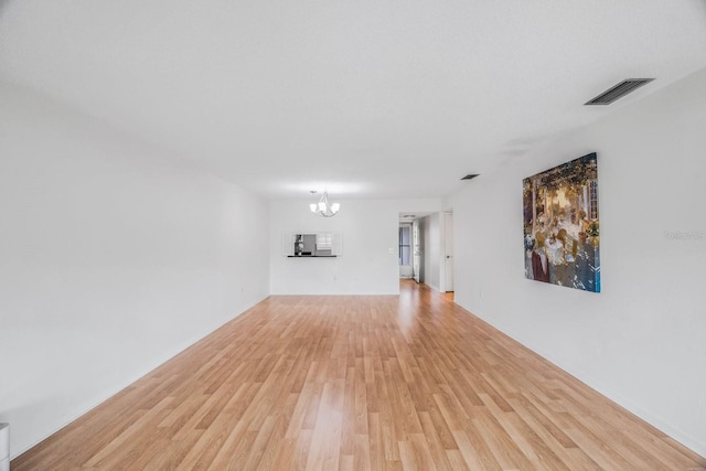 interior space with a notable chandelier and light wood-type flooring