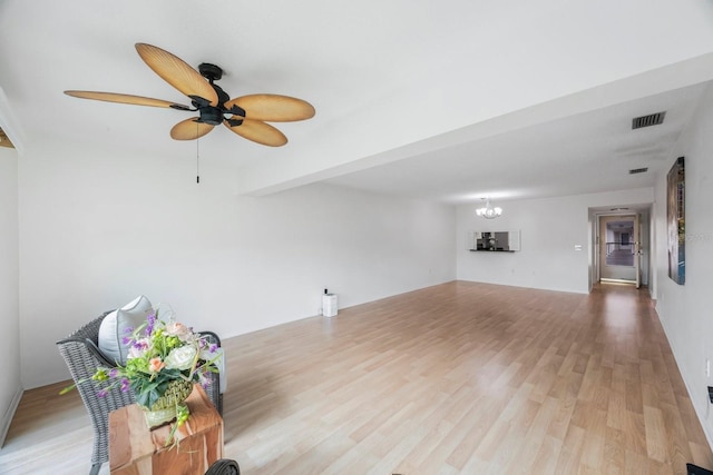 unfurnished living room featuring ceiling fan with notable chandelier, beamed ceiling, and hardwood / wood-style floors