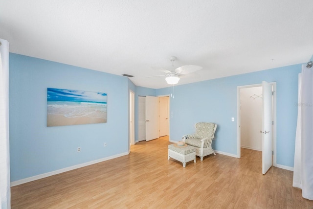 sitting room with ceiling fan and light hardwood / wood-style flooring