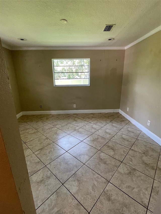 tiled spare room featuring a textured ceiling and crown molding