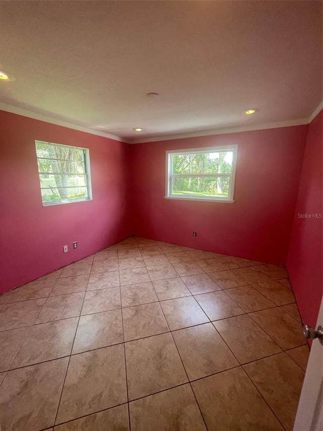 tiled empty room featuring crown molding