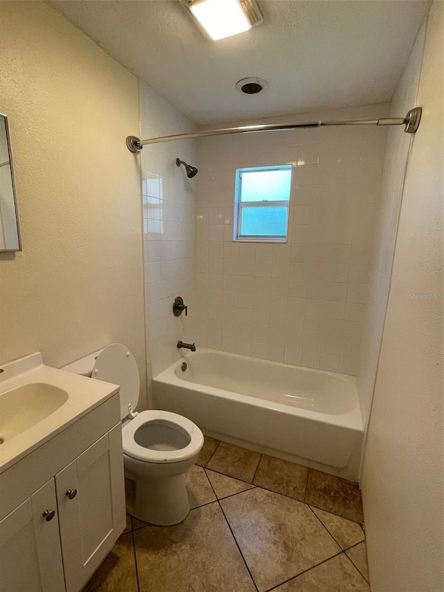 full bathroom featuring toilet, tile patterned flooring, vanity, a textured ceiling, and tiled shower / bath combo