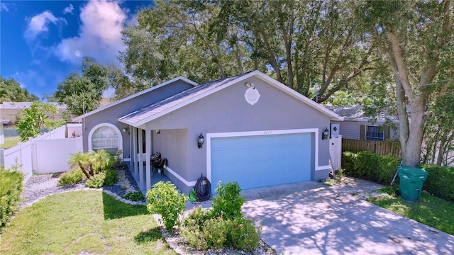 4477 67th St N, Saint Petersburg, FL 33709 - ranch-style house with stucco siding, fence, driveway, and a garage