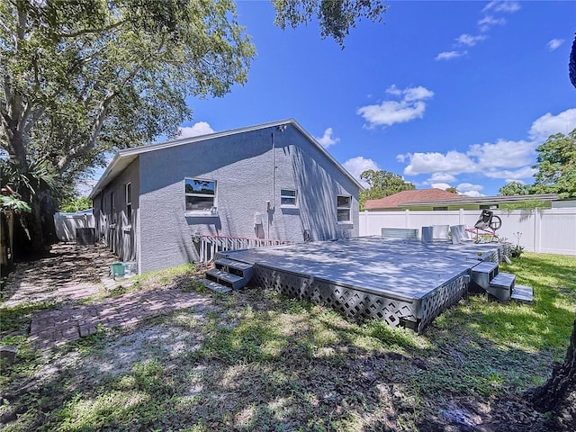 4477 67th St N, Saint Petersburg, FL 33709 - rear view of property featuring a wooden deck, stucco siding, and fence