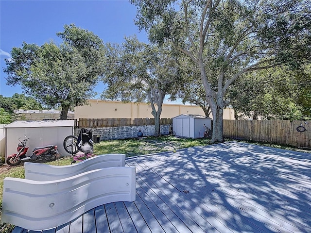4477 67th St N, Saint Petersburg, FL 33709 - wooden terrace featuring an outdoor structure, a storage unit, and a fenced backyard