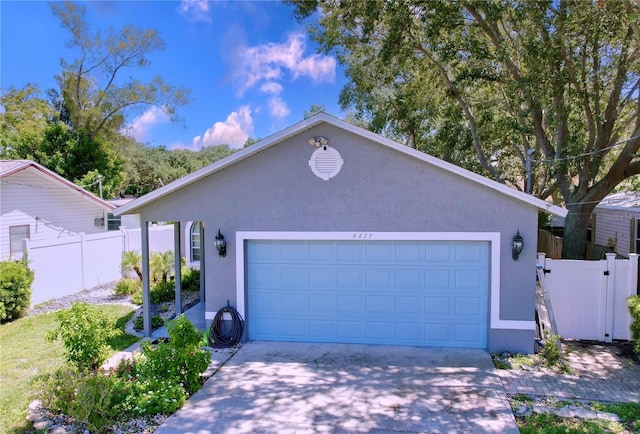 4477 67th St N, Saint Petersburg, FL 33709 - ranch-style home with fence, an attached garage, concrete driveway, and stucco siding