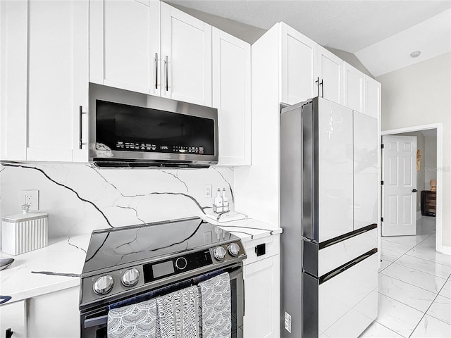 4477 67th St N, Saint Petersburg, FL 33709 - kitchen with range with electric cooktop, stainless steel microwave, freestanding refrigerator, marble finish floor, and light stone countertops