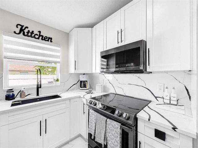 4477 67th St N, Saint Petersburg, FL 33709 - kitchen featuring white cabinets, backsplash, black electric range oven, and a sink