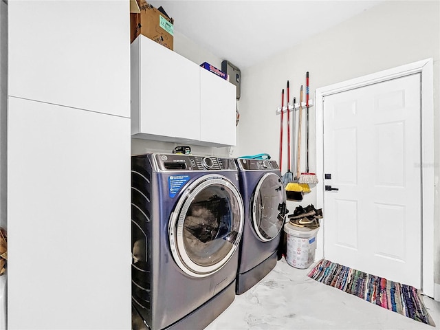 washroom featuring cabinets and washing machine and dryer