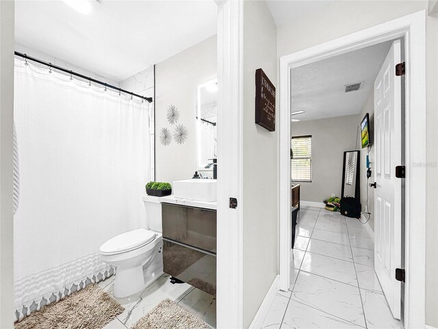 4477 67th St N, Saint Petersburg, FL 33709 - bathroom featuring toilet, vanity, marble finish floor, baseboards, and visible vents