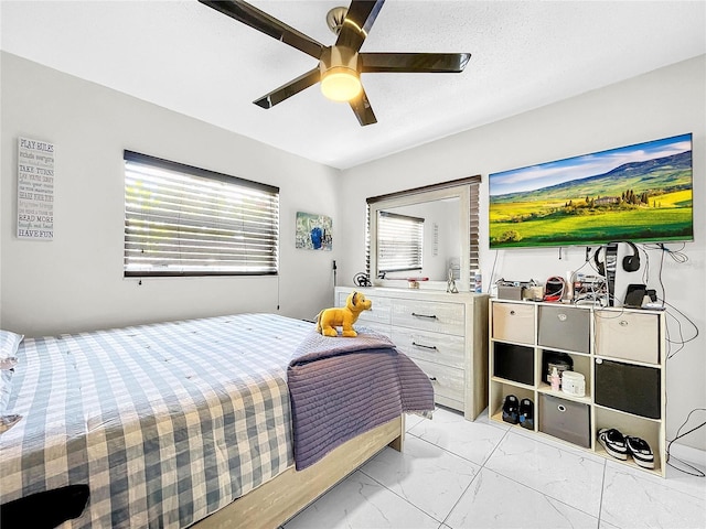 bedroom with multiple windows, ceiling fan, and a textured ceiling