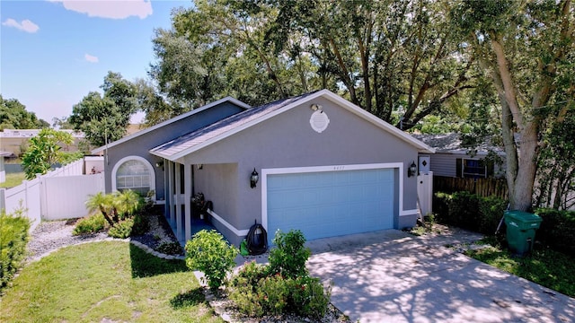 4477 67th St N, Saint Petersburg, FL 33709 - ranch-style home with a front lawn, concrete driveway, fence, a garage, and stucco siding