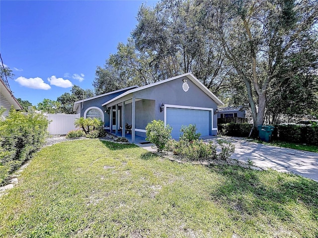 4477 67th St N, Saint Petersburg, FL 33709 - view of front facade featuring concrete driveway, fence, an attached garage, a front yard, and stucco siding