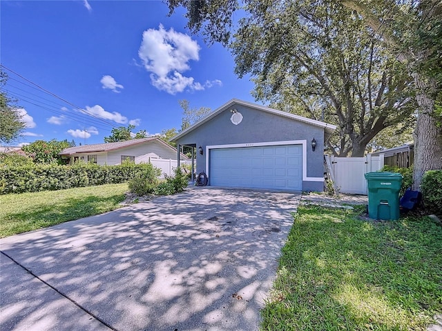 4477 67th St N, Saint Petersburg, FL 33709 - ranch-style home featuring a front lawn, driveway, fence, a garage, and stucco siding