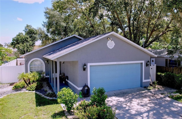 4477 67th St N, Saint Petersburg, FL 33709 - view of front facade with a garage, stucco siding, concrete driveway, and fence
