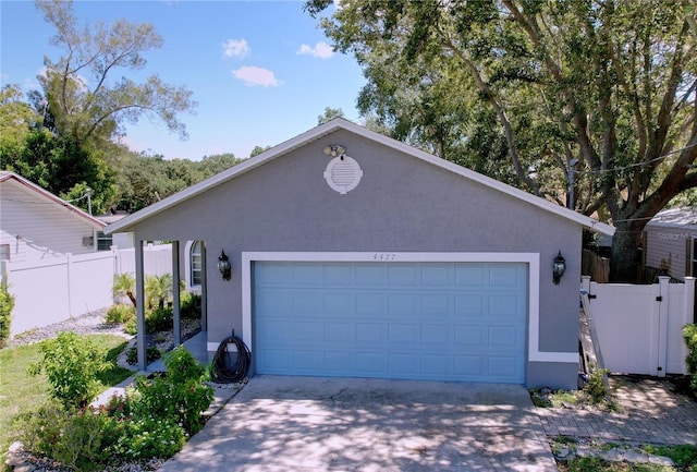 4477 67th St N, Saint Petersburg, FL 33709 - view of front of house featuring fence, concrete driveway, and stucco siding