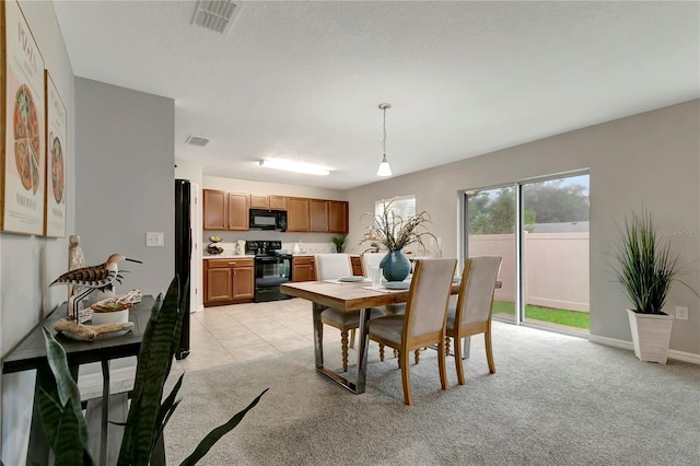 dining room featuring a textured ceiling and light colored carpet