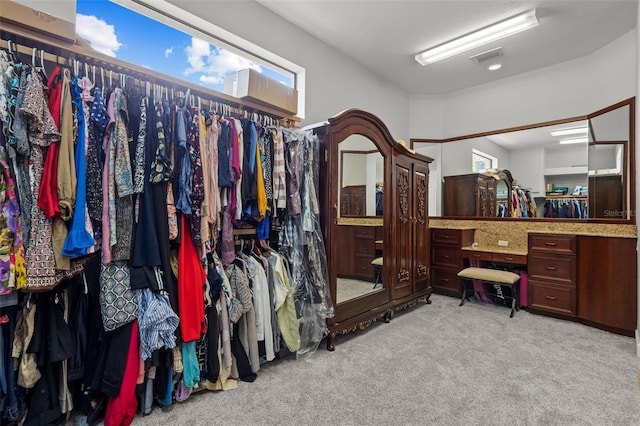 walk in closet featuring light carpet