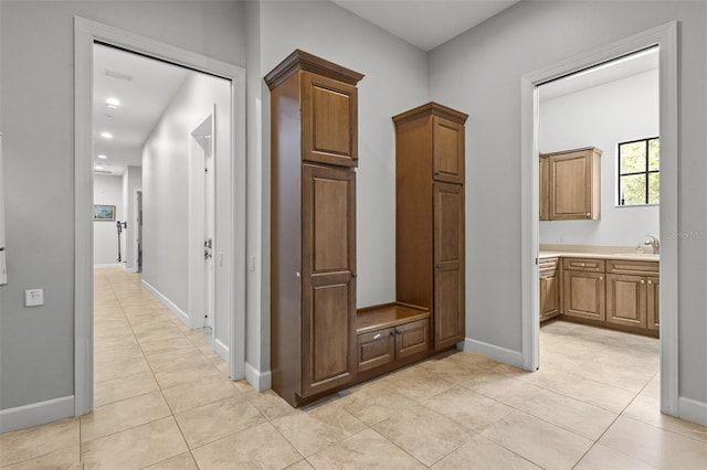 hall with sink and light tile patterned floors